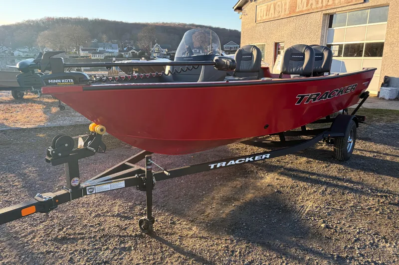 Slide: The Image of 2026 Tracker Pro Guide V-16 SC boat on trailer, red exterior, parked outdoors. - 80