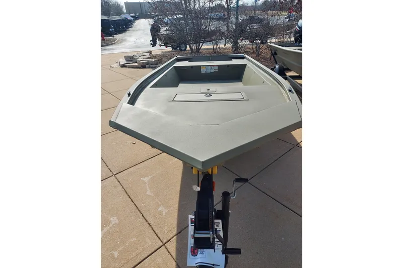 Slide: The Image of 2026 Tracker Grizzly 1648 Utility boat displayed outdoors on pavement. - 2