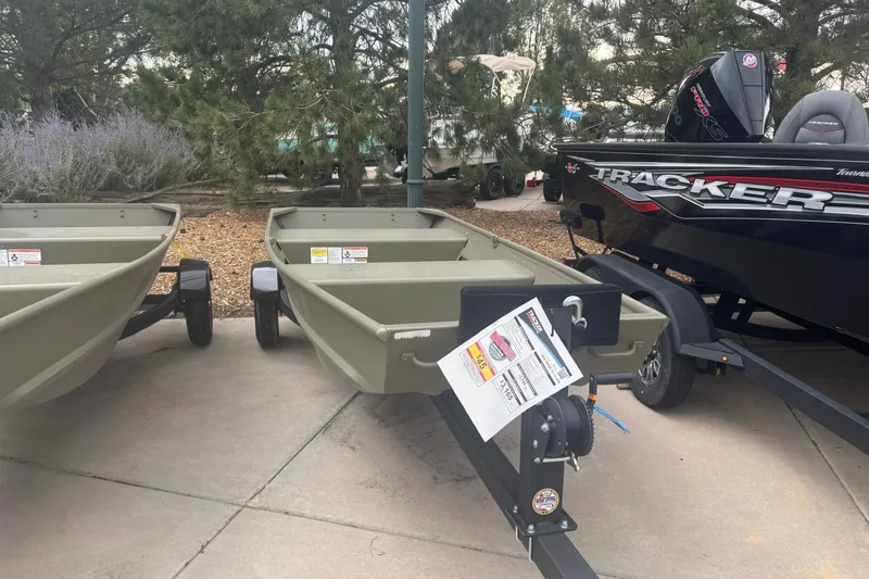 The Image of 2026 Tracker Grizzly 12 Jon boat displayed outdoors with trailer. - 0