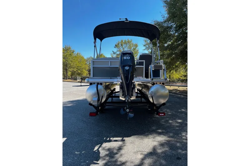 Slide: The Image of 2026 Sun Tracker Bass Buggy 16 XL Select pontoon boat, rear view with motor. - 3