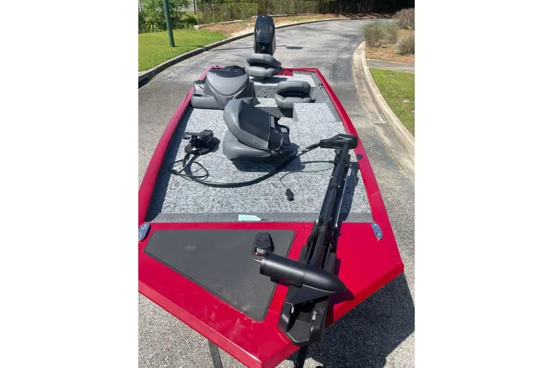 Slide: The Image of 2026 Tracker Pro 170 boat with red exterior and gray interior, parked on pavement. - 4