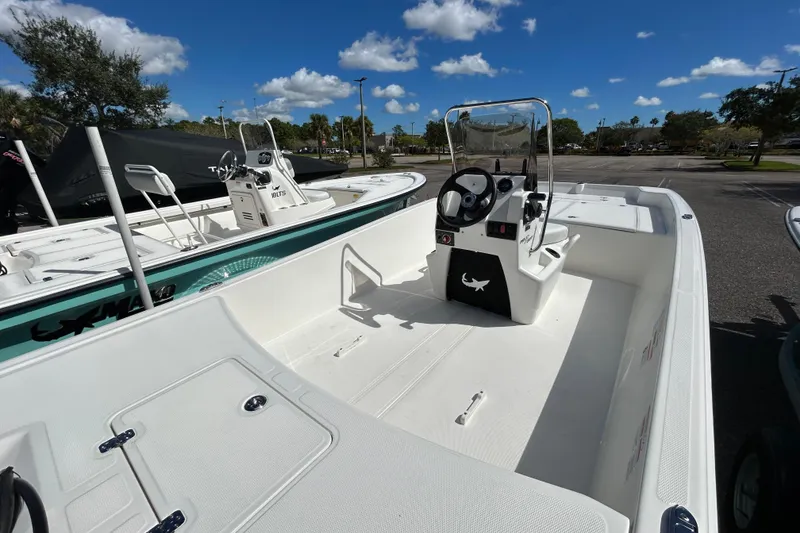 Slide: The Image of 2026 Mako Pro Skiff 17 CC boat with center console, parked under a clear blue sky. - 3