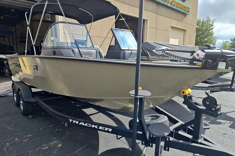 The Image of 2026 Tracker Targa V-18 Combo boat on trailer, parked outside a building. - 0