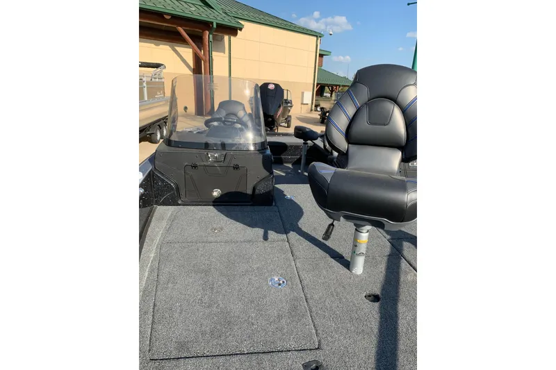 Slide: The Image of 2025 Nitro ZV20 boat interior with seating and console, parked outdoors. - 6