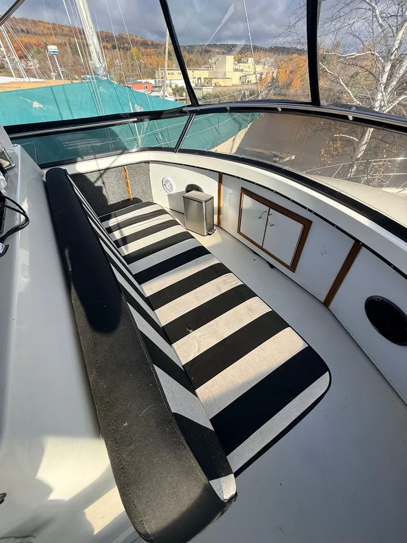 Slide: The Image of 1987 Carver 42 Cockpit Motor Yacht interior with striped seating and scenic view. - 20