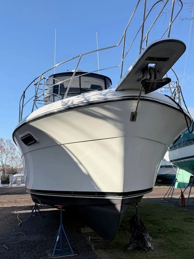 Slide: The Image of 1987 Carver 42 Cockpit Motor Yacht on stands, viewed from the front, under clear blue sky. - 5