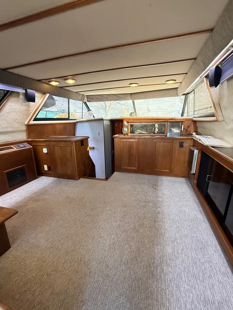 Slide: The Image of 1987 Carver 42 Cockpit Motor Yacht interior with wood cabinetry and carpeted flooring. - 8