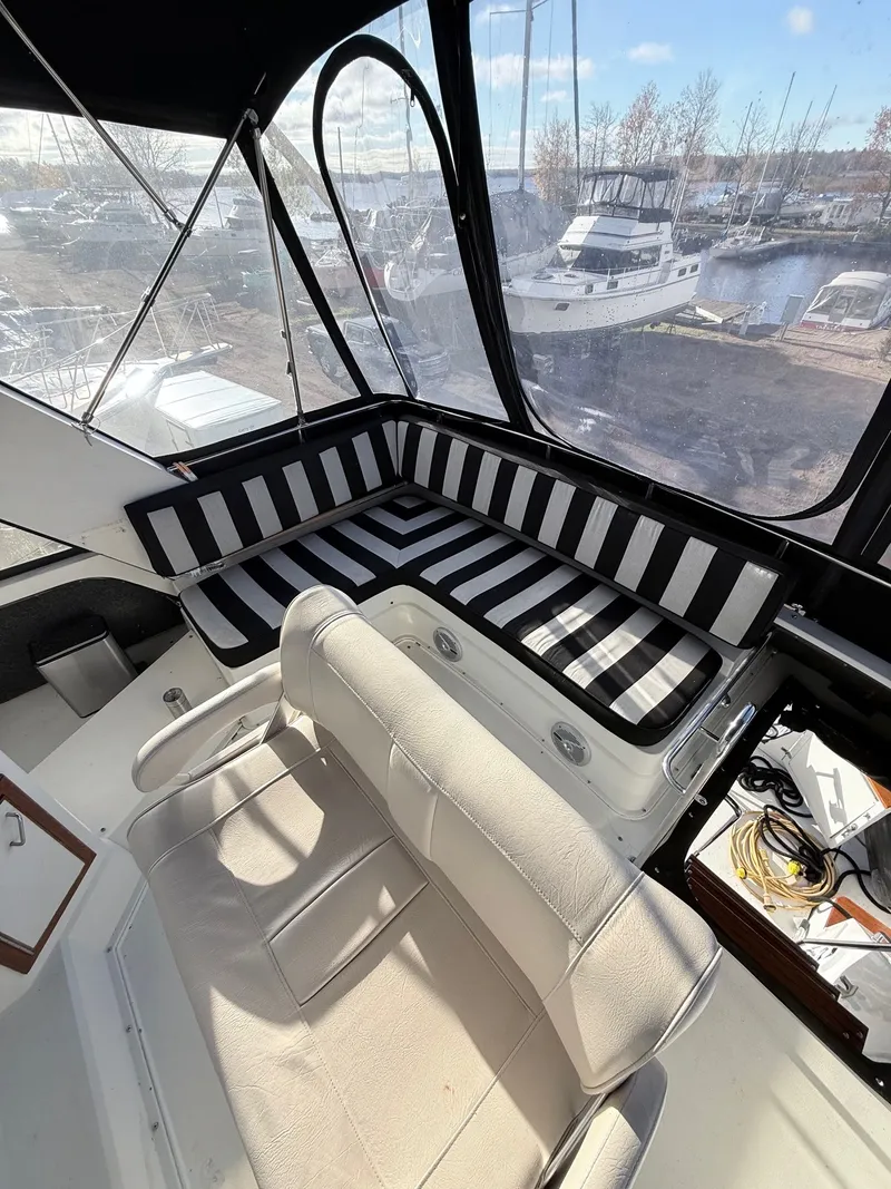 Slide: The Image of 1987 Carver 42 Cockpit Motor Yacht interior with striped seating and marina view. - 22