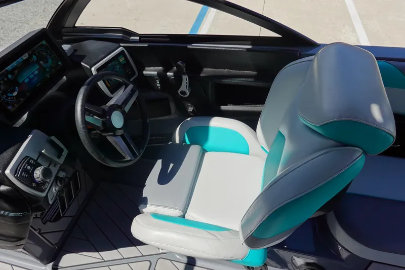 Slide: The Image of 2019 Malibu Wakesetter 23 LSV interior with modern dashboard and teal-accented captain's chair. - 17