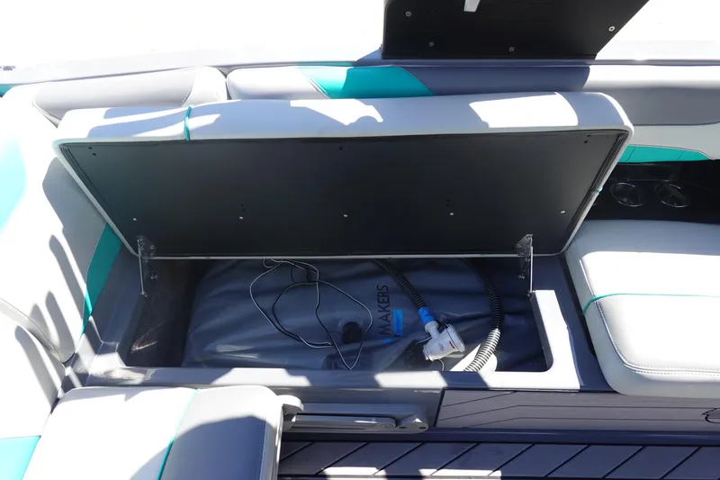 Slide: The Image of 2019 Malibu Wakesetter 23 LSV storage compartment with open lid and visible equipment. - 25