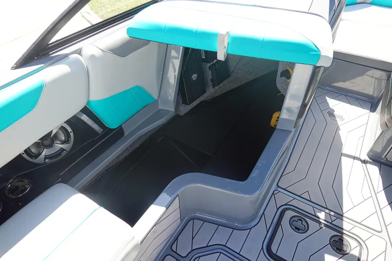 Slide: The Image of 2019 Malibu Wakesetter 23 LSV interior with teal and gray seating, open storage compartment. - 26