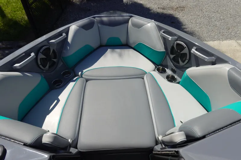 Slide: The Image of 2019 Malibu Wakesetter 23 LSV boat interior with gray and teal seating, cup holders, and speakers. - 31
