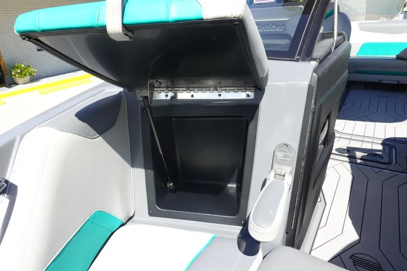 Slide: The Image of 2019 Malibu Wakesetter 23 LSV interior storage compartment with open lid, showcasing seating design. - 32