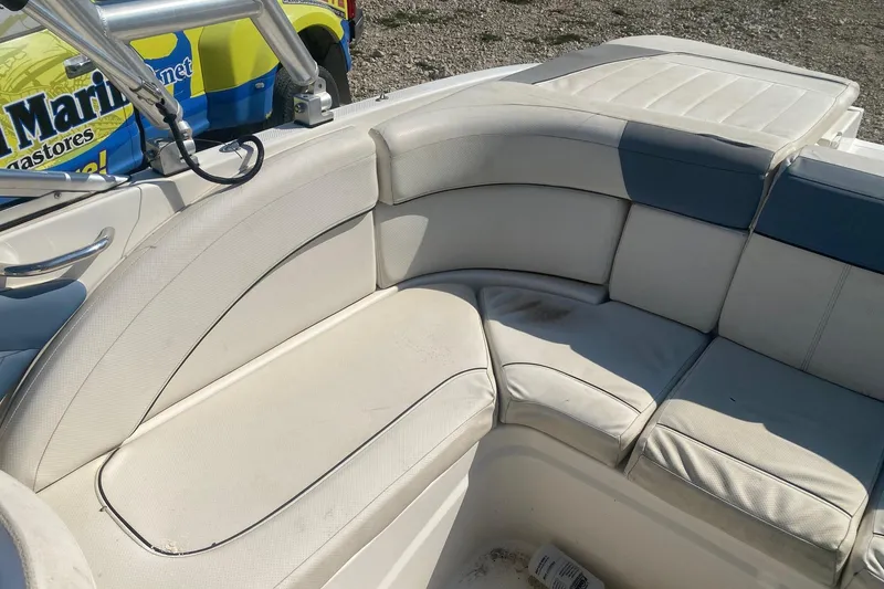 Slide: The Image of 2012 Bayliner 235 Bowrider interior with white cushioned seating and metal railing. - 9