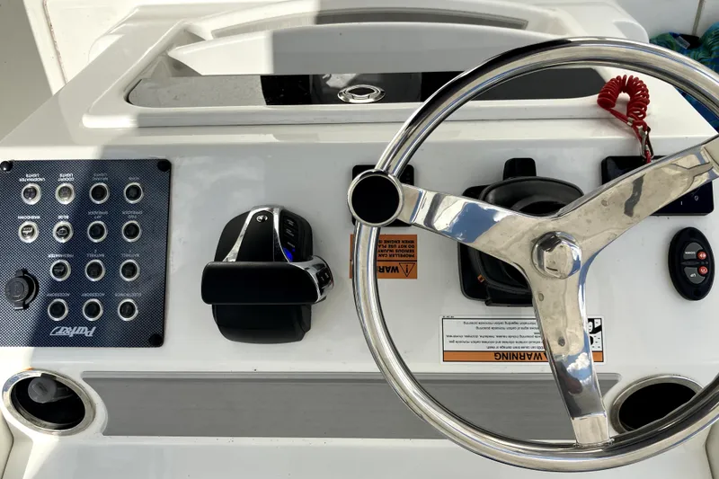 Slide: The Image of 2024 Parker 2200 Center Console boat dashboard with steering wheel and control panel. - 10