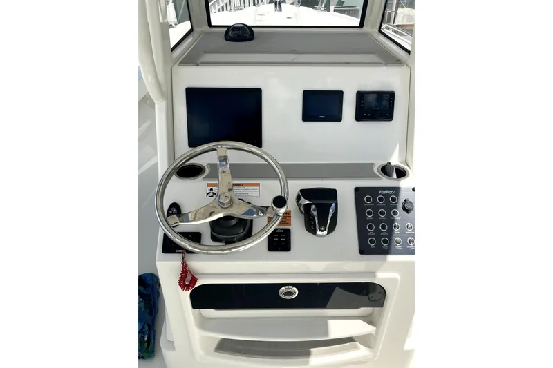 Slide: The Image of 2024 Parker 2200 Center Console boat dashboard with steering wheel and control panel. - 16