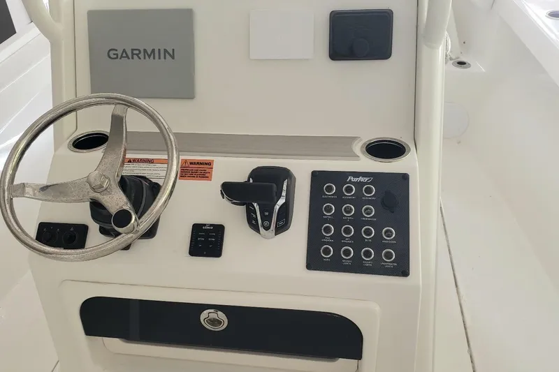 Slide: The Image of 2024 Parker 2200 Center Console boat dashboard with Garmin navigation and control panel. - 2