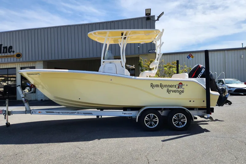 Slide: The Image of 2013 Sea Fox 226 Commander boat on trailer, labeled "Rum Runners Revenge," parked outside a building. - 0