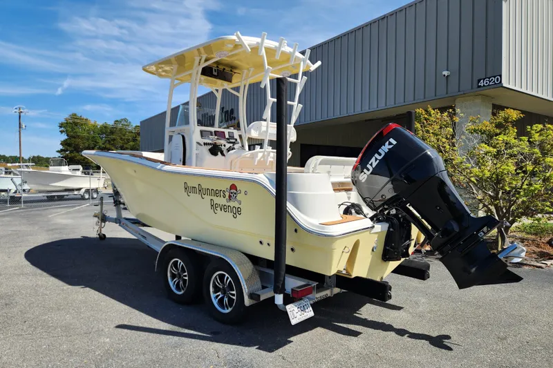 Slide: The Image of 2013 Sea Fox 226 Commander boat with Suzuki engine on trailer, labeled "Rum Runners Revenge." - 2