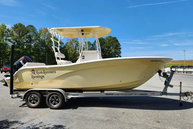 Slide: The Image of 2013 Sea Fox 226 Commander boat on trailer, labeled "Rum Runners Revenge," parked outdoors. - 6