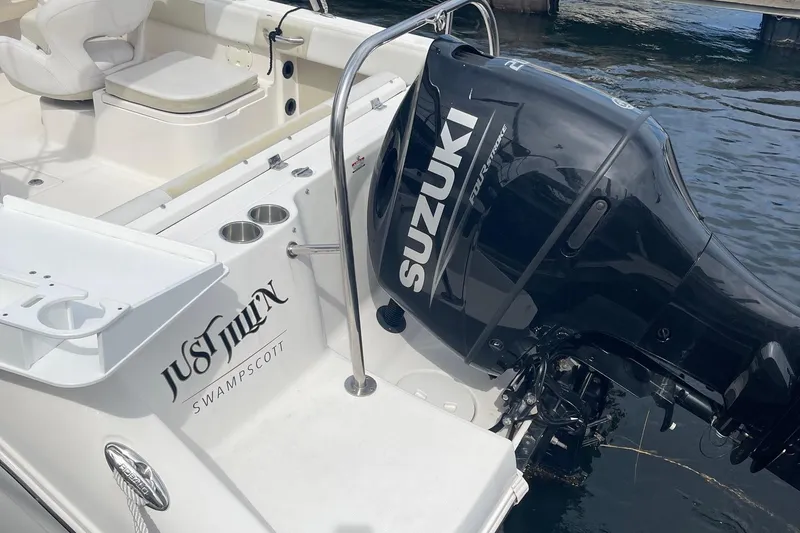 Slide: The Image of 2016 Robalo R227 Dual Console boat with Suzuki outboard motor, docked on water. - 8