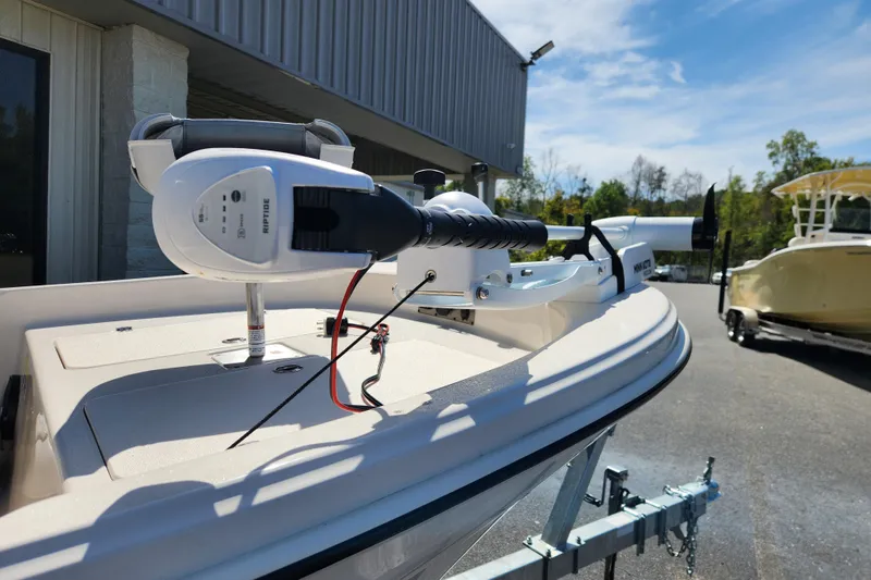 Slide: The Image of 2025 Carolina Skiff 178 JLS boat with trolling motor, parked outdoors. - 6