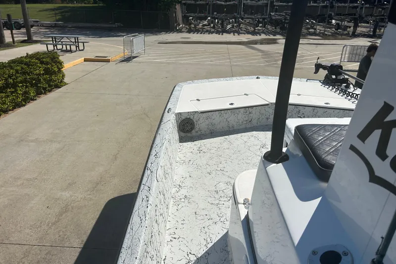 Slide: The Image of 2020 Dargel Kat 250 HDX boat parked on concrete, featuring a textured deck and seating. - 24