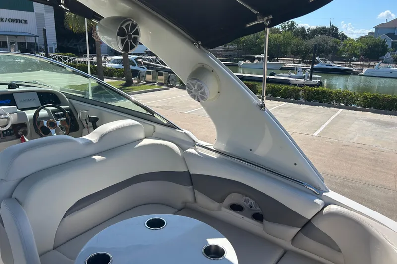 Slide: The Image of 2008 Chaparral 275 SSi boat interior with seating, speakers, and steering wheel, docked by the marina. - 10