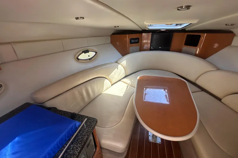 Slide: The Image of Interior of 2008 Chaparral 275 SSi boat with beige seating and wooden table. - 18