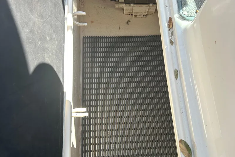 Slide: The Image of 2008 Chaparral 275 SSi boat storage compartment with black mat and leaves. - 22