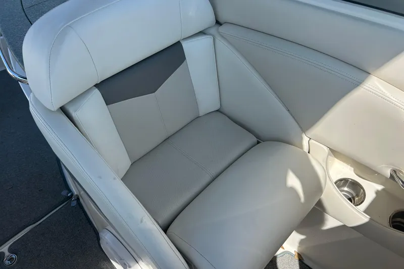 Slide: The Image of 2008 Chaparral 275 SSi boat interior seat with cup holders, featuring light gray upholstery. - 30