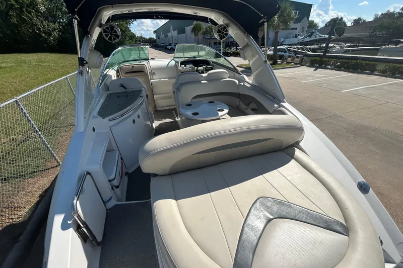 Slide: The Image of 2008 Chaparral 275 SSi boat interior with seating and table, docked outdoors. - 39