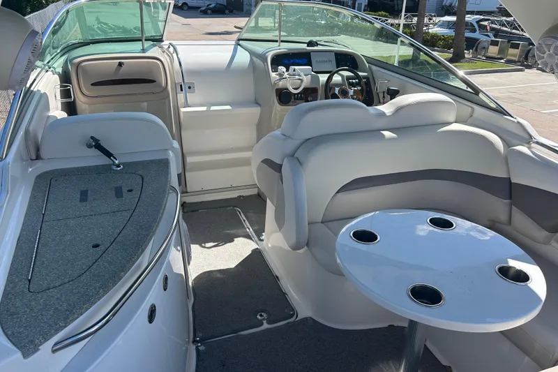 Slide: The Image of 2008 Chaparral 275 SSi boat interior with seating, table, and helm in sunlight. - 6