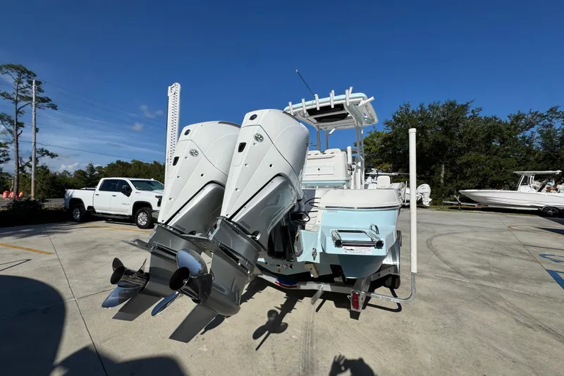 Slide: The Image of 2026 Caymas 281 HB boat with dual outboard engines in a parking lot. - 16