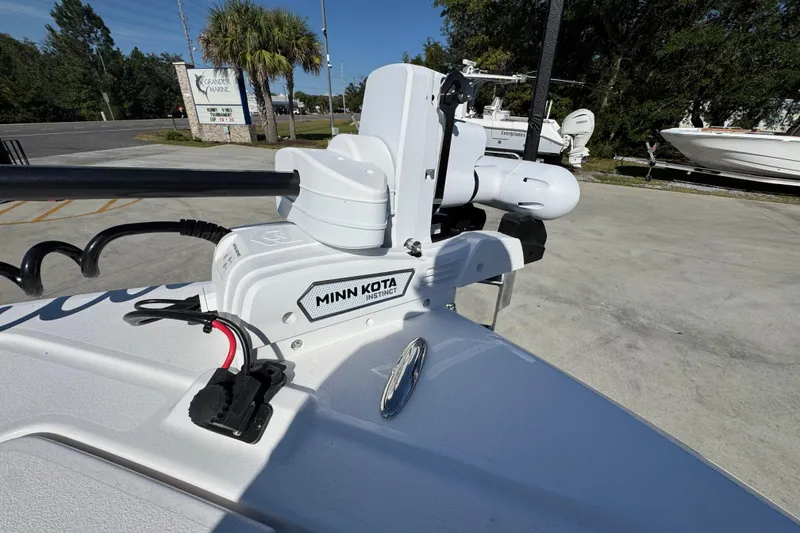 Slide: The Image of 2026 Caymas 281 HB boat with Minn Kota trolling motor in a marina setting. - 24