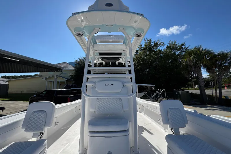 Slide: The Image of 2026 Caymas 281 HB boat interior with white seating and helm station under clear blue sky. - 28