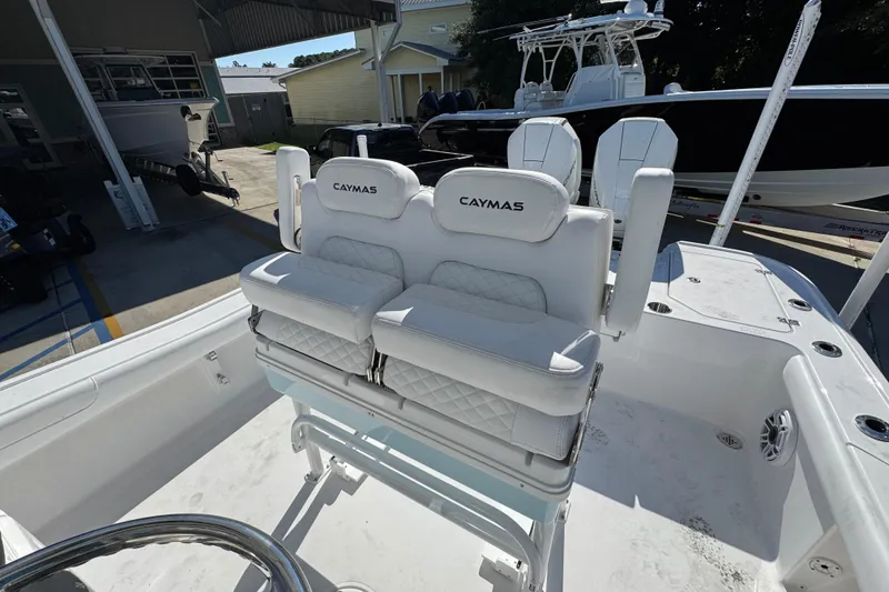 Slide: The Image of 2026 Caymas 281 HB boat with white cushioned seating in a marina setting. - 31