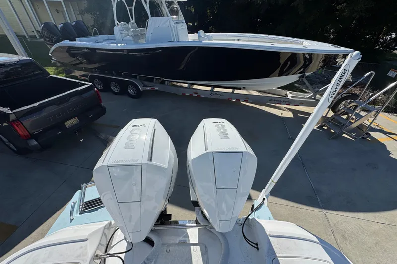 Slide: The Image of 2026 Caymas 281 HB boat on trailer, twin Mercury engines, parked beside a truck. - 37