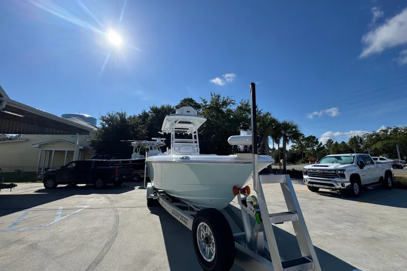 Slide: The Image of 2026 Caymas 281 HB boat on trailer under sunny sky, surrounded by vehicles. - 8