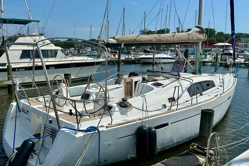 Slide: The Image of 2011 Beneteau Oceanis 40 sailboat docked in a marina, featuring dual steering wheels. - 6