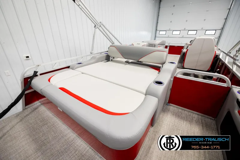 Slide: The Image of 2026 Avalon VEN85 VRB pontoon boat interior with red and gray seating in a showroom. - 25