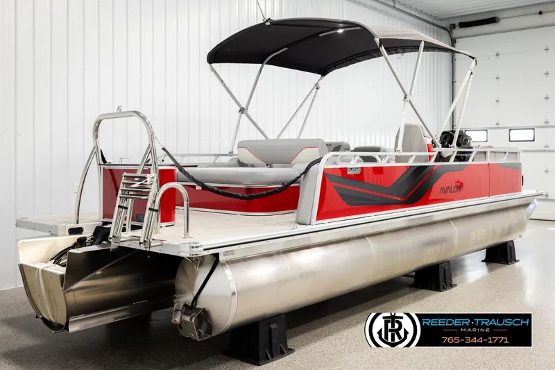 Slide: The Image of 2026 Avalon VEN85 VRB pontoon boat in a showroom with red and black design. - 6