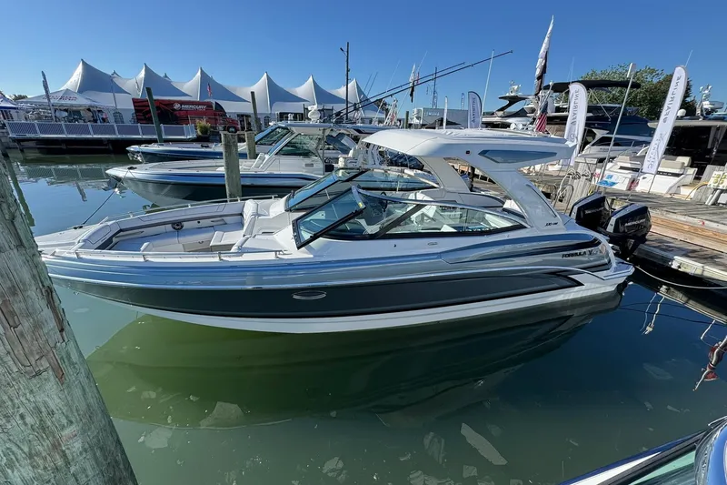 Slide: The Image of 2026 Formula 330 Crossover Bowrider OB docked at a marina under clear blue skies. - 2