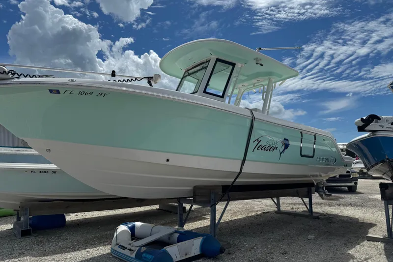 Slide: The Image of 2021 Robalo R272 Center Console boat on display under a partly cloudy sky. - 0
