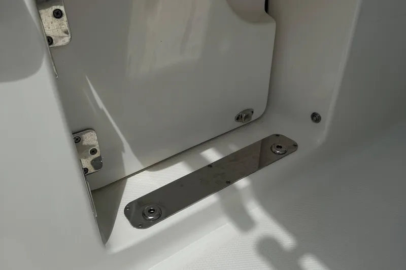Slide: The Image of 2021 Robalo R272 Center Console boat interior detail with metal hinges and fittings. - 11
