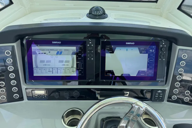 Slide: The Image of 2021 Robalo R272 Center Console dashboard with dual Simrad displays and steering wheel. - 14