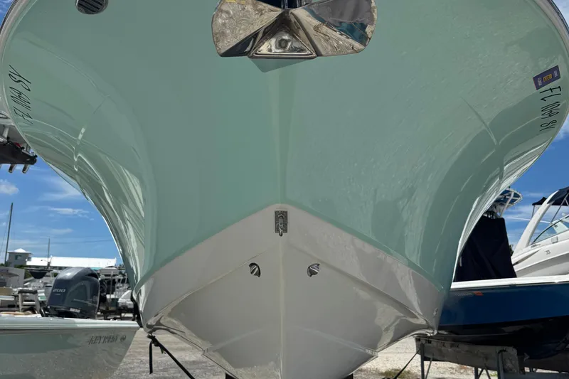 Slide: The Image of 2021 Robalo R272 Center Console boat hull, displayed outdoors on a sunny day. - 2