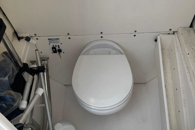 Slide: The Image of 2021 Robalo R272 Center Console boat interior with toilet and storage area. - 22