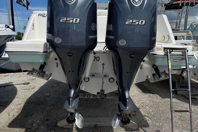 Slide: The Image of 2021 Robalo R272 Center Console with twin Yamaha 250 engines, docked on gravel. - 3