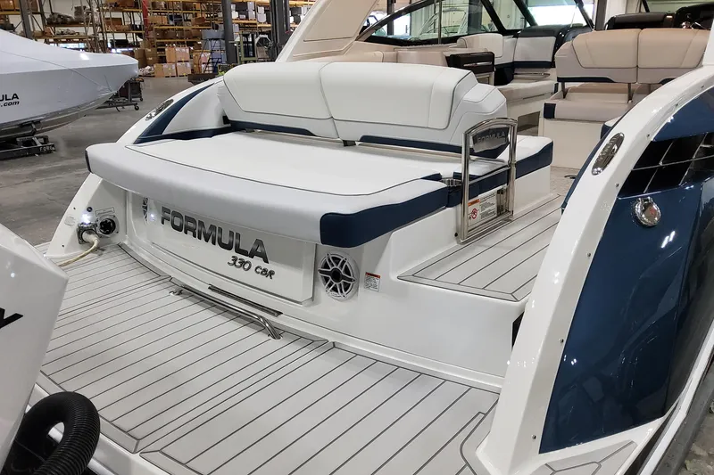 Slide: The Image of 2026 Formula 330 Crossover Bowrider OB, luxury boat interior with seating, in a showroom. - 12